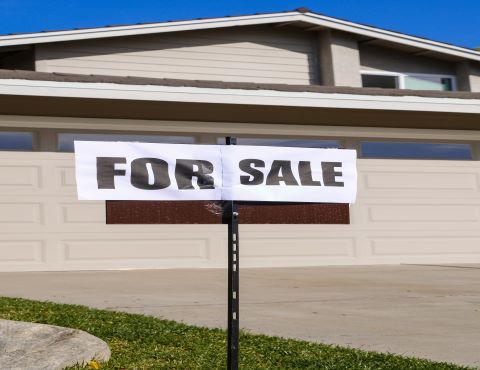 for sale sign in front of house